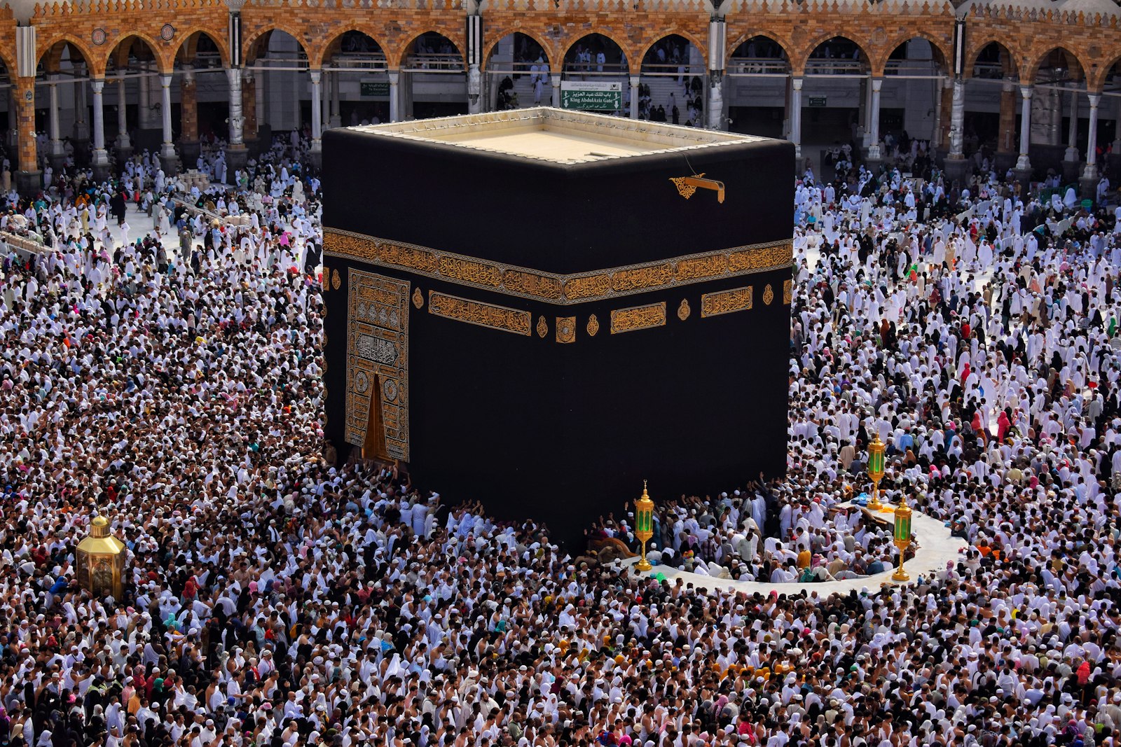 Vue plongeante sur la Kaaba entourée d’une foule dense de pèlerins vêtus de blanc accomplissant le tawaf.