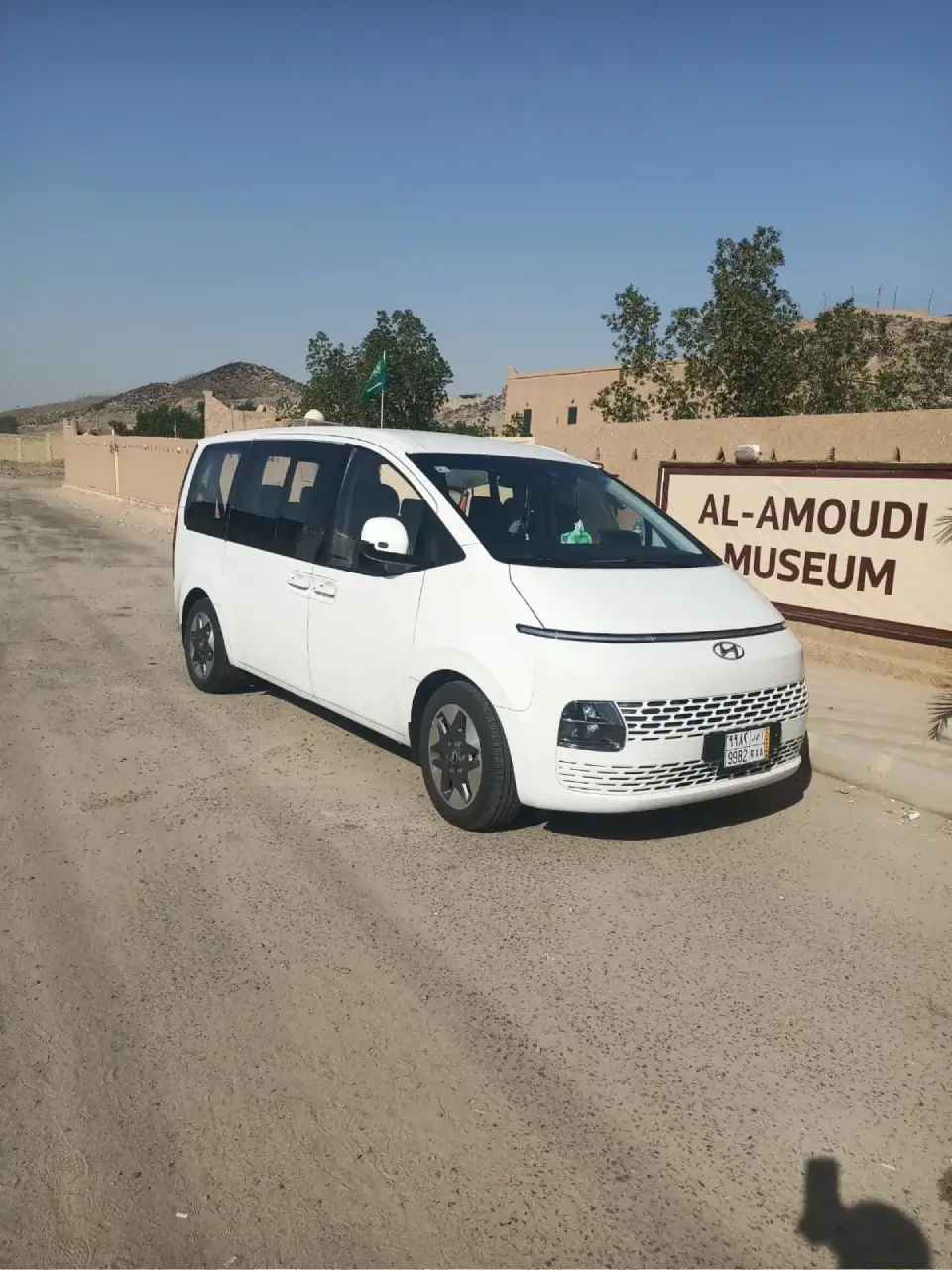 Van Staria blanc sur une piste, devant le panneau d’un musée.